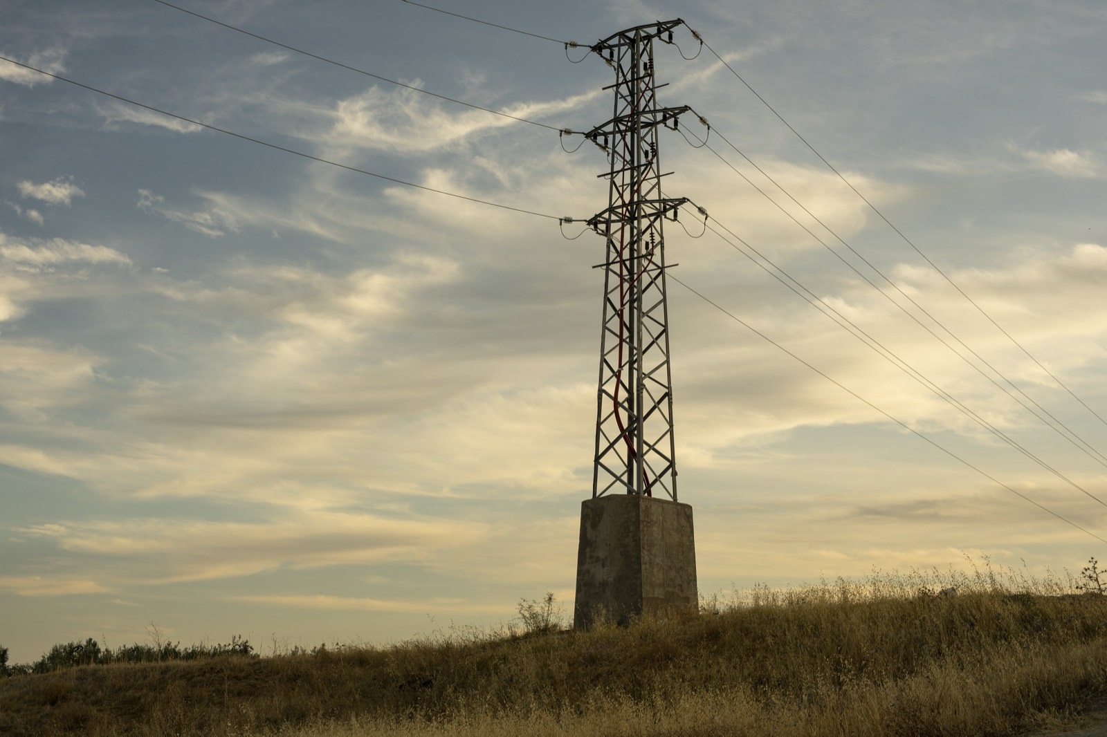 High-voltage power transmission towers at sunrise